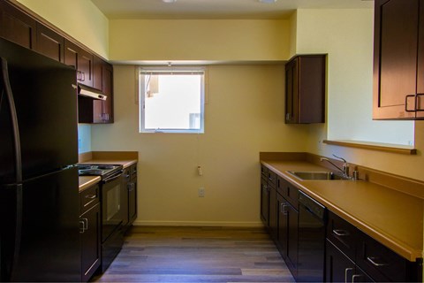 A kitchen with black appliances and wooden cabinets.