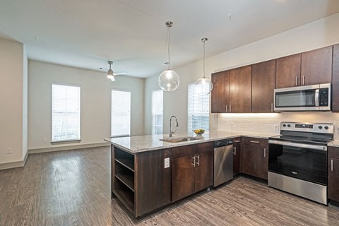 A modern kitchen with dark wood cabinets and stainless steel appliances.