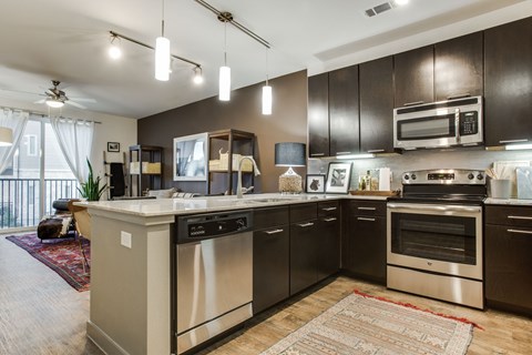 an open kitchen with stainless steel appliances and a counter top