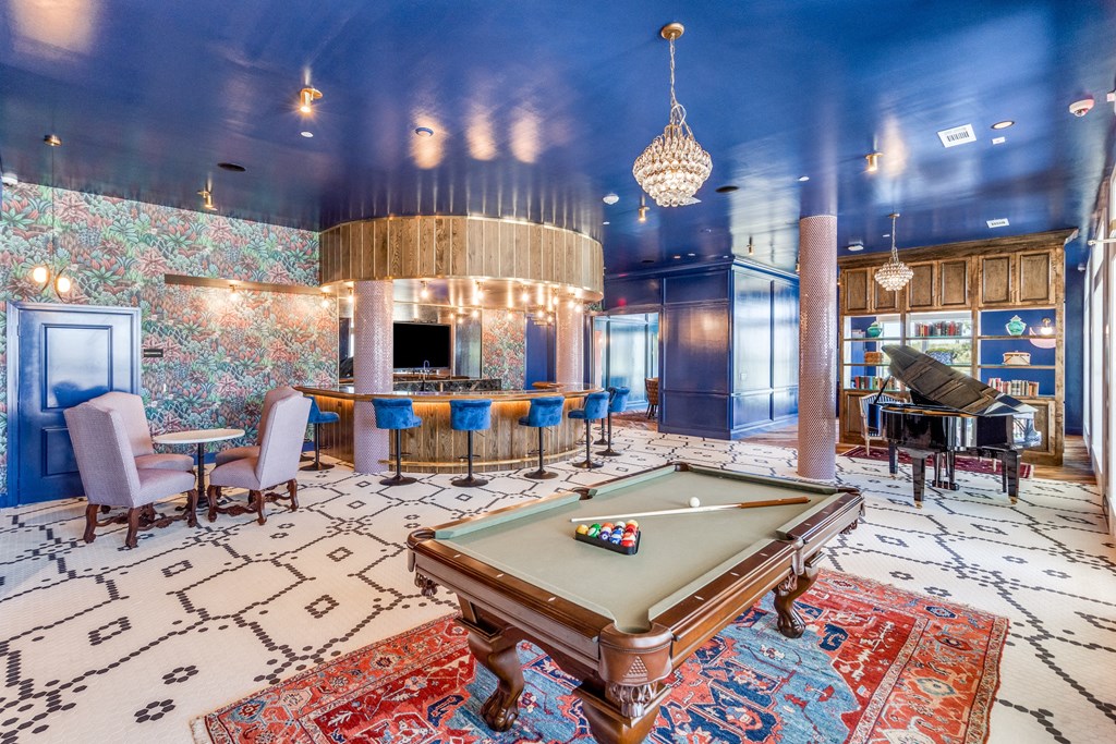 a pool table and piano in a large room with blue walls and a chandelier