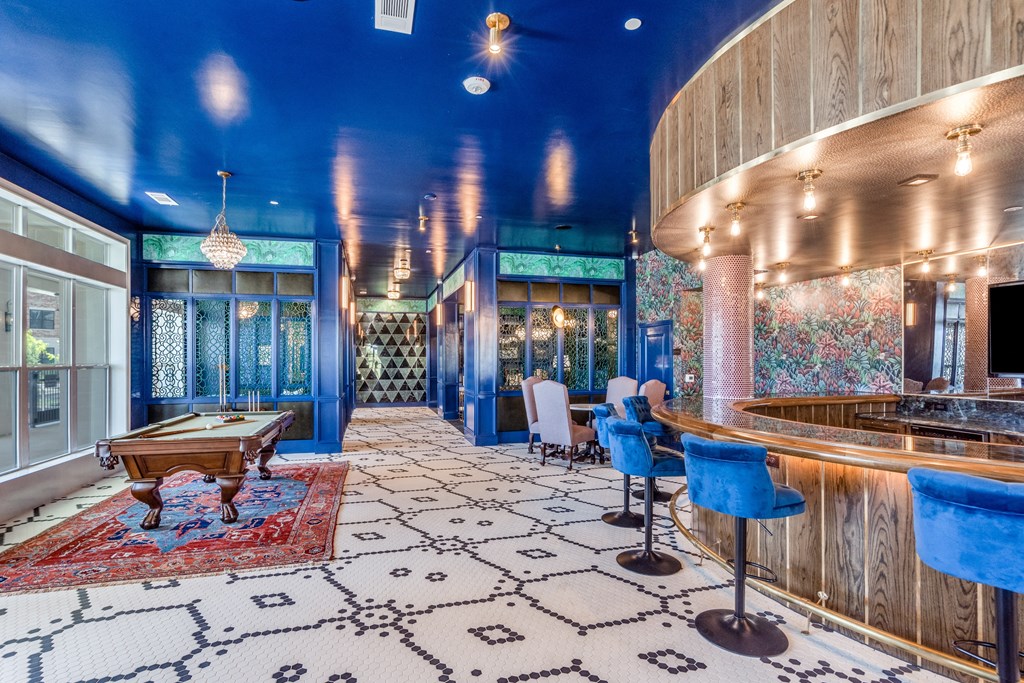 a pool table sits in the middle of a room with a bar