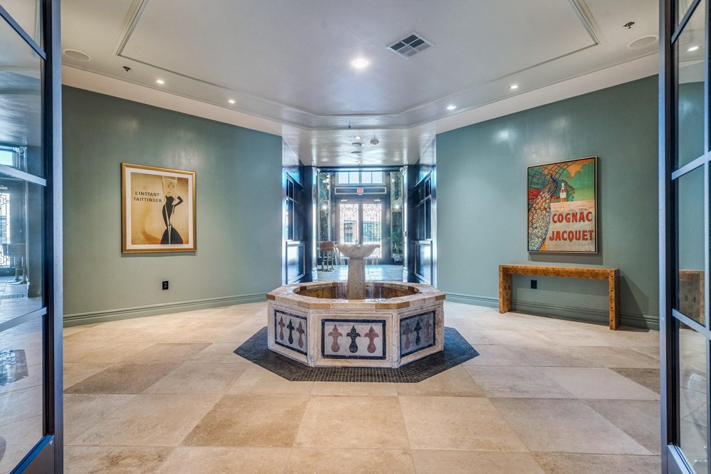 the lobby of a building with a fountain in the center