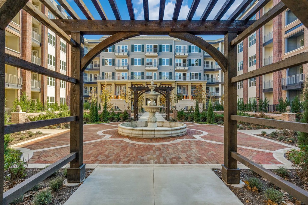a view of a courtyard with a fountain and an apartment building