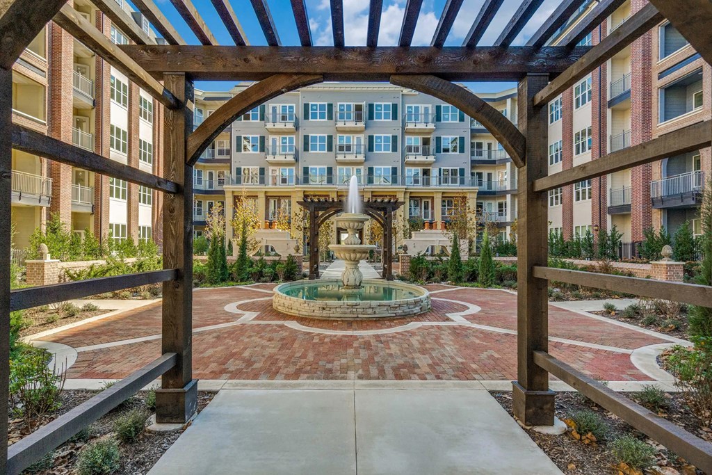 a view of a courtyard with a fountain and an apartment building