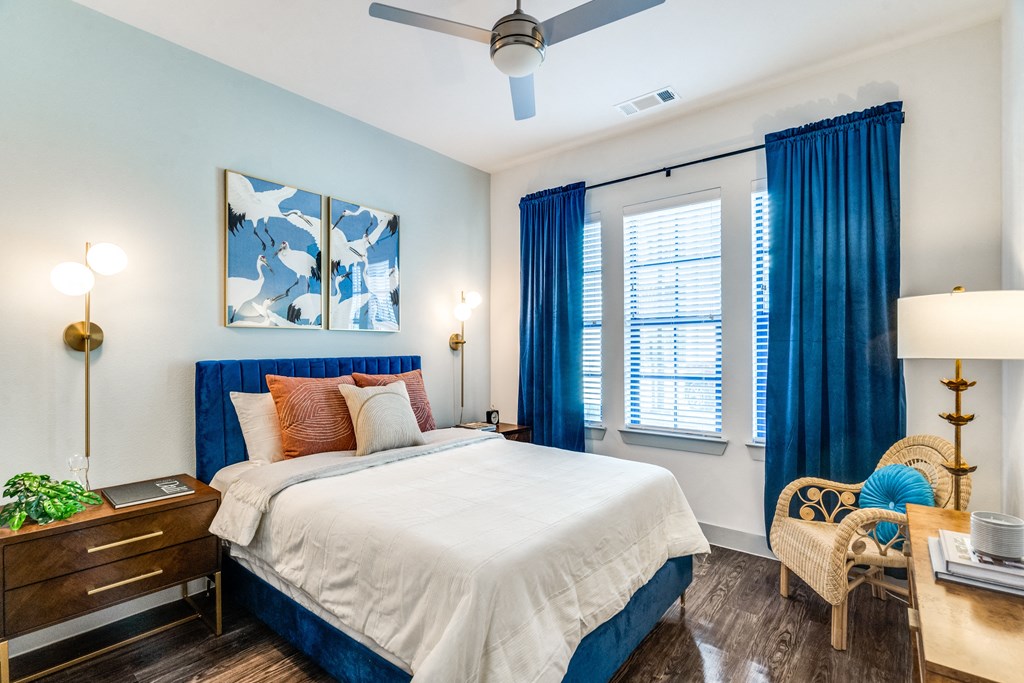 a bedroom with a white bed and blue curtains
