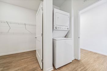 an empty laundry room with a washer and dryer and white walls and wood  at Plat 4 at Research Triangle, Durham, 27703