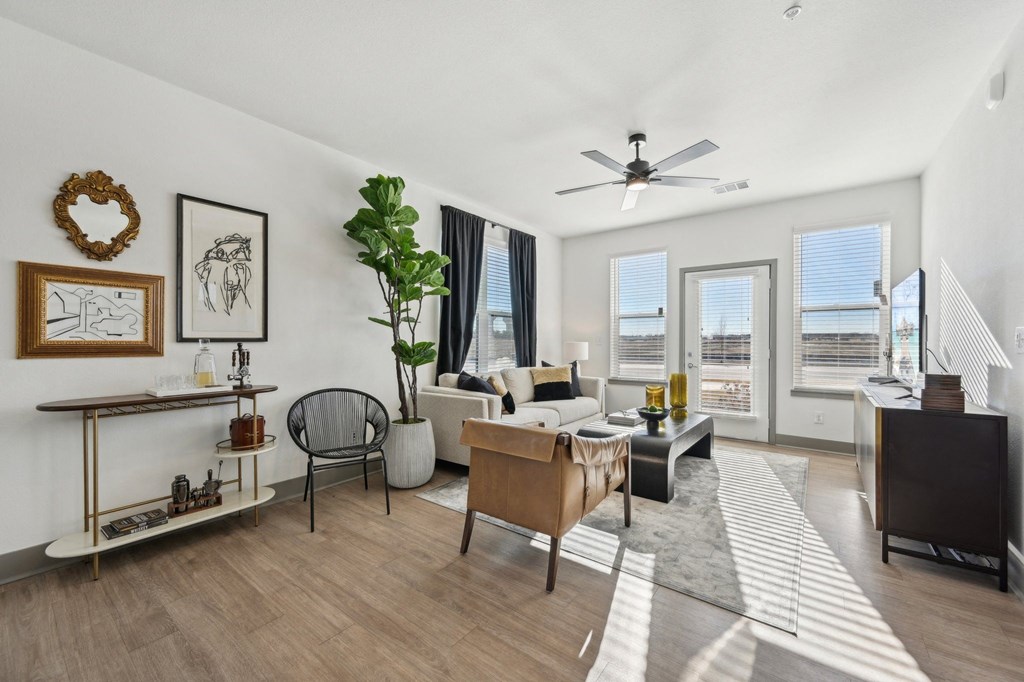 A living room with a couch, chair, and a plant.