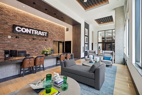 A living room with a brick wall and a sign that says "CONTRAST".