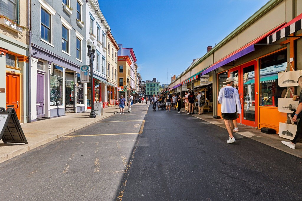 Busy Findlay Market street scene in Over-the-Rhine Cincinnati with colorful storefronts and pedestrians near Contrast OTR.