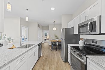 A modern kitchen with stainless steel appliances and white cabinets.