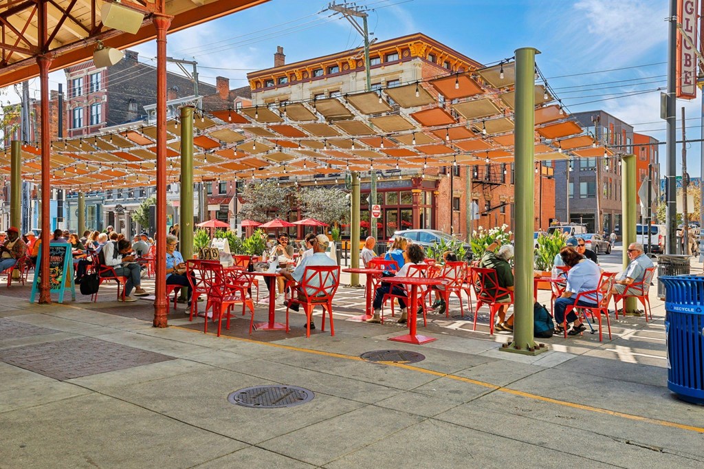 Shaded patio dining area at Findlay Market's Over-the-Rhine district with string lights and colorful architecture.