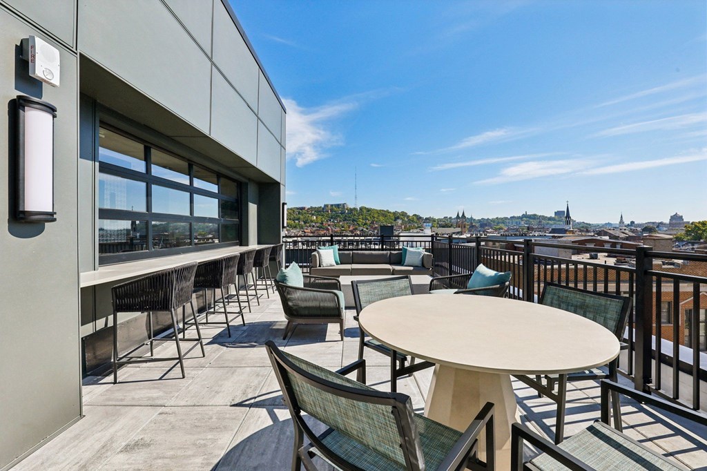 A patio with a table and chairs overlooking a city.
