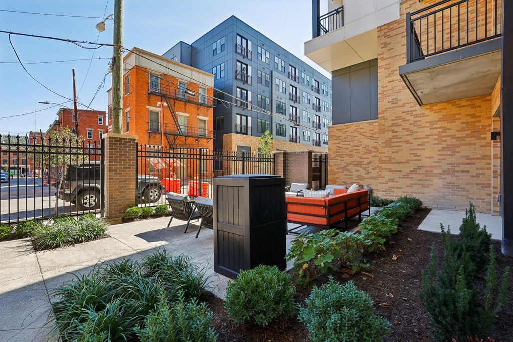 Stylish outdoor seating area at Contrast OTR in Over-the-Rhine Cincinnati with modern chairs, greenery, and community grill.