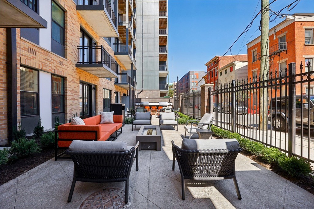 Seating area with a patio with a couch, chairs and a table in the middle of it.