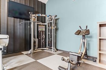 a gym with exercise equipment and a tv on the wall  at Plat 4 at Research Triangle, Durham, NC, 27703