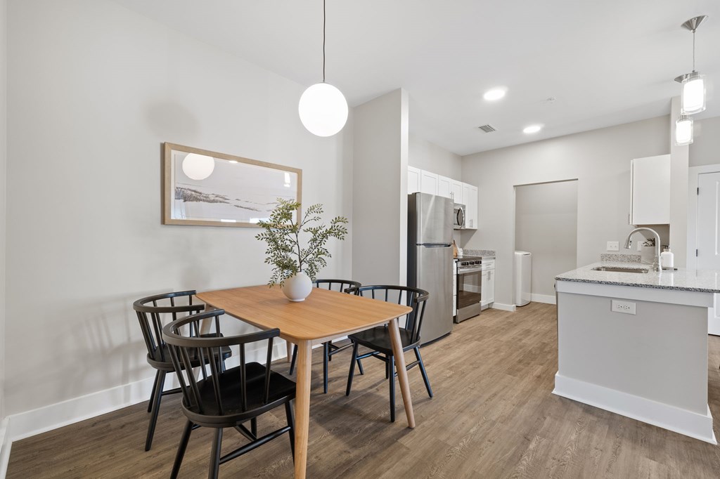 A modern kitchen with a dining table and chairs.