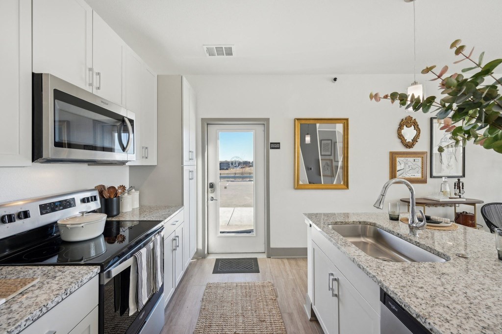 A kitchen with granite countertops and stainless steel appliances.