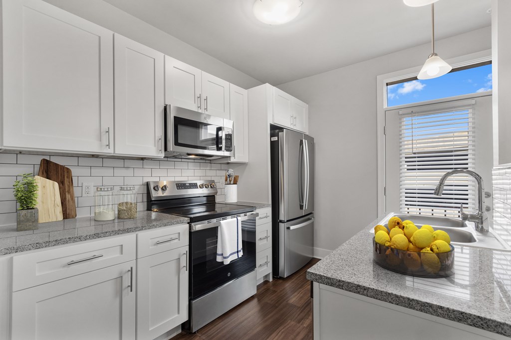 A kitchen with white cabinets and a granite countertop. A kitchen with white cabinets and a granite countertop at CityWay Apartments, Indiana 46204