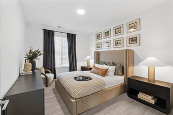A well-lit bedroom with a large bed and a nightstand.