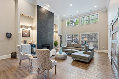 A living room with a grey sofa, a white chair and a grey armchair.