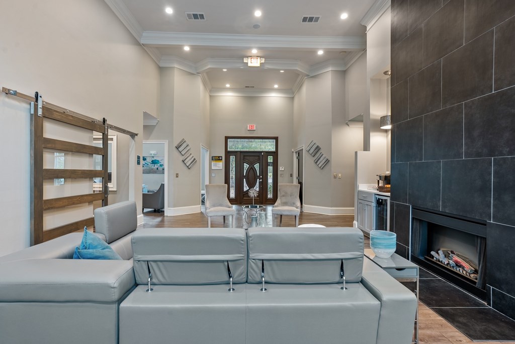 Spacious clubhouse lounge with tall ceilings and cozy seating at Village at Almand Creek apartments.