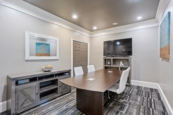 A conference room with a wooden table and chairs.