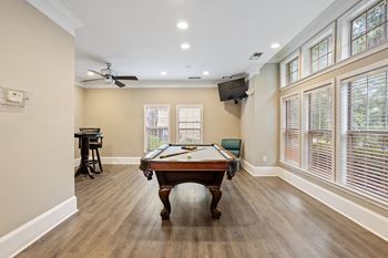 A room with a pool table and a ceiling fan.