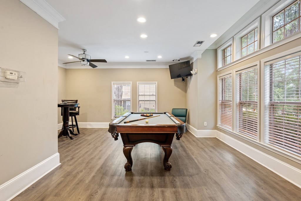 Billiards room with pool table and seating at Village at Almand Creek apartments.