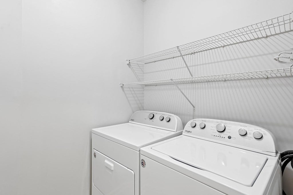 In-unit laundry room with full-size Whirlpool washer and dryer at Village at Almand Creek Apartments in Conyers, GA.