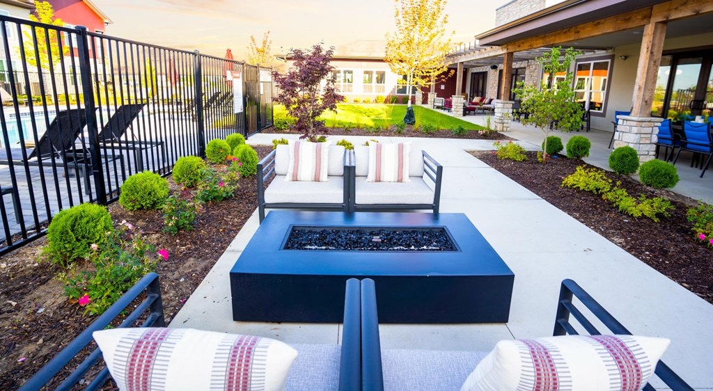 a fire pit in the middle of a patio with chairs