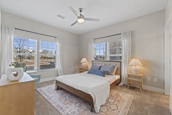 A bedroom with a bed, nightstands, and a ceiling fan.