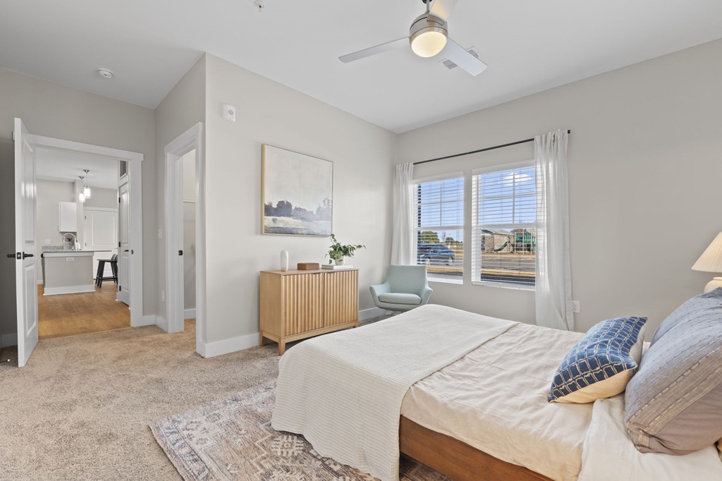 A bedroom with a bed, a dresser, and a painting on the wall.