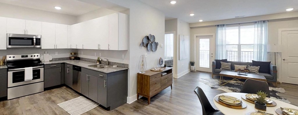 an open kitchen and living room with a table and chairs at Echo Park at Perry Crossing Apartments, Indiana