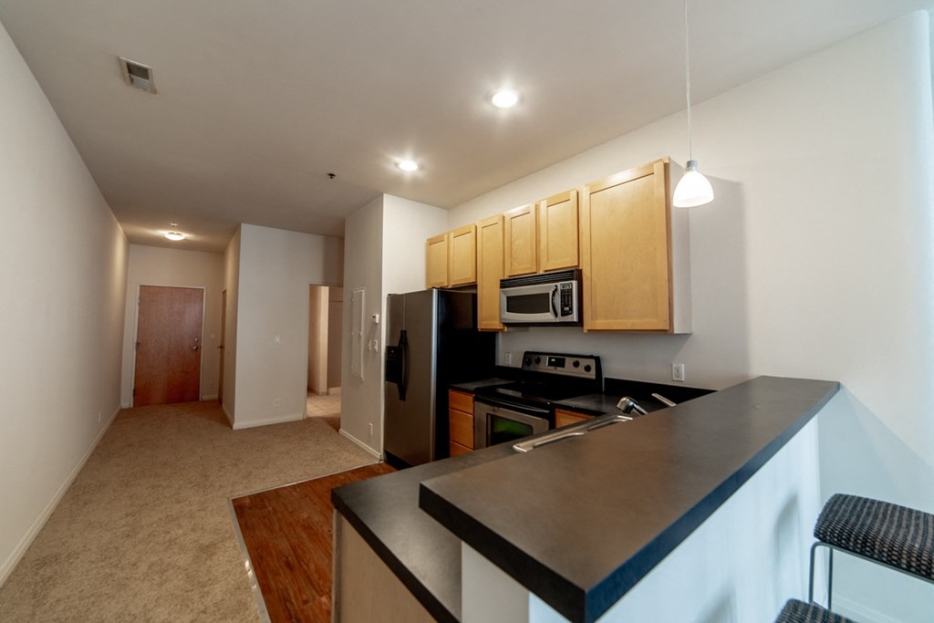 a kitchen with a black counter top and a black stove top oven at 26 West, Managed by Buckingham Urban Living, Indianapolis