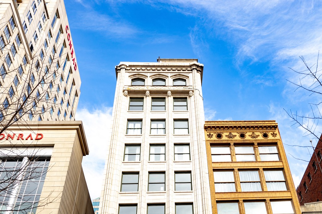 looking up at a tall white building with a blue sky in the background at 26 West, Managed by Buckingham Urban Living, Indianapolis