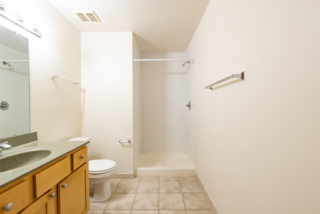 a bathroom with a toilet sink and bathtub at 26 West, Managed by Buckingham Urban Living, Indianapolis