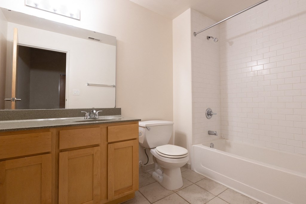 a bathroom with a toilet sink and bathtub at 26 West, Managed by Buckingham Urban Living, Indianapolis