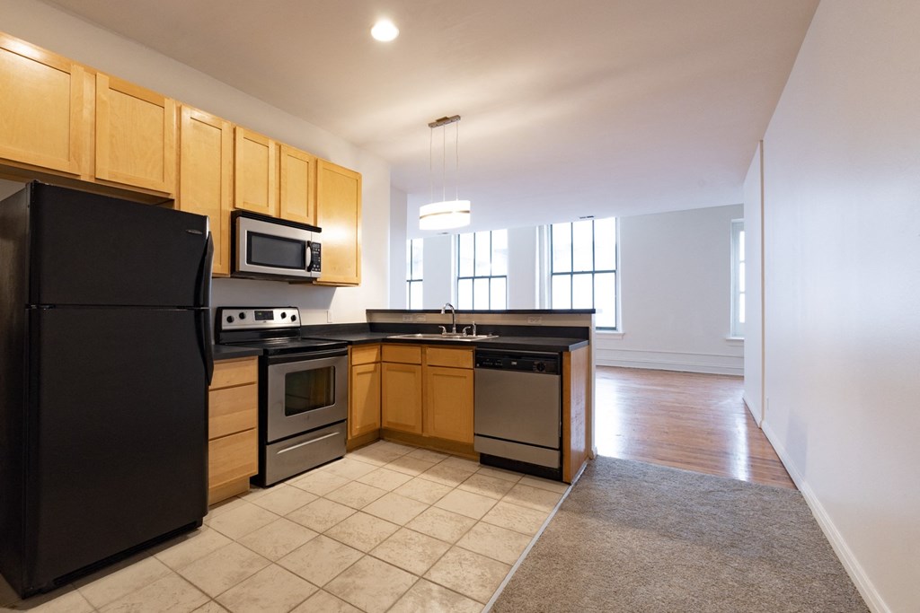 a kitchen with wooden cabinets and black appliances at 26 West, Managed by Buckingham Urban Living, Indianapolis