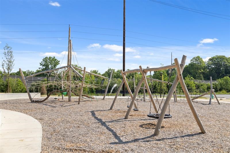 Rope climbing playground and wooden swing set at Nook Nine community