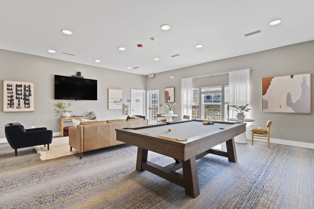 A room with a pool table and a tv.