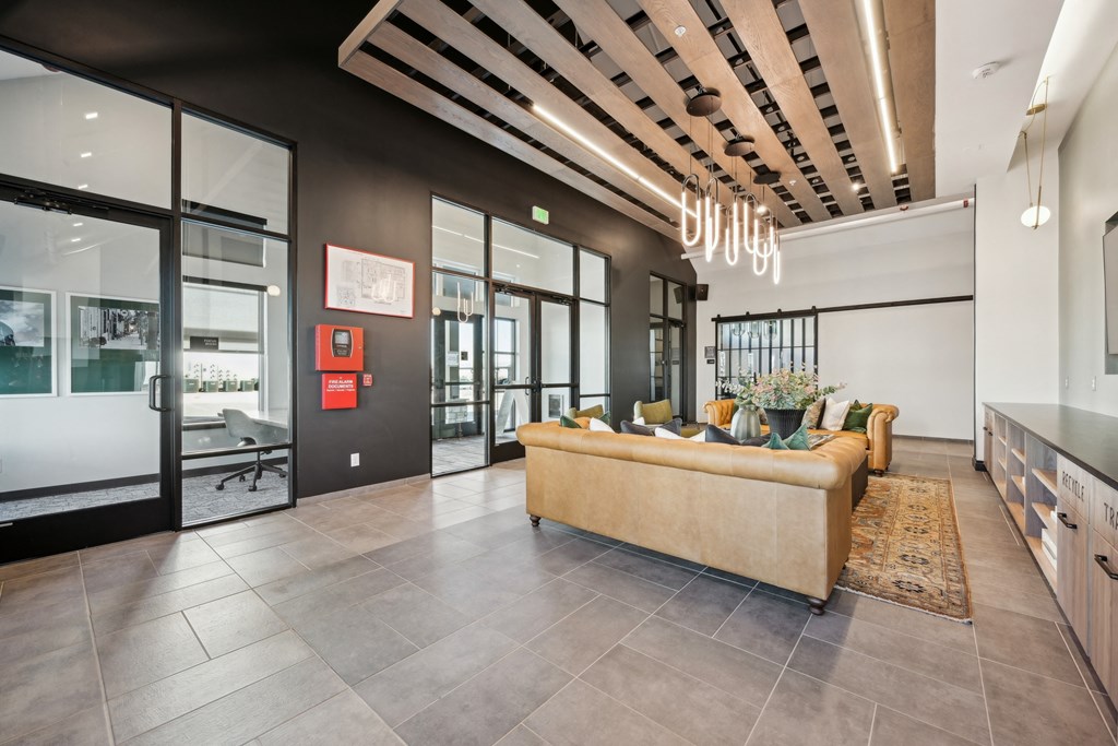 A modern living room with a sofa, a coffee table, and a kitchen area.