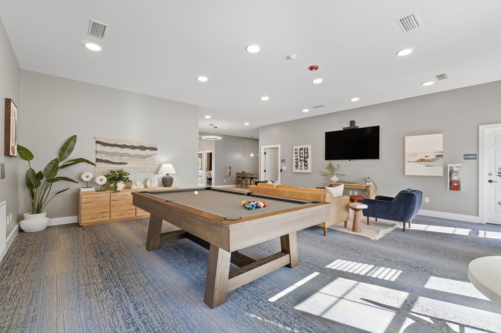 A room with a pool table and a television.