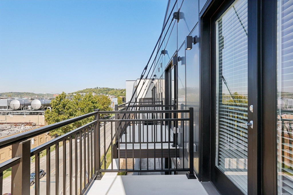 Private balcony at Contrast OTR apartments in Cincinnati, OH with sleek glass doors and city views.