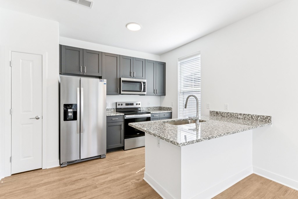 A kitchen with a granite countertop and stainless steel appliances.