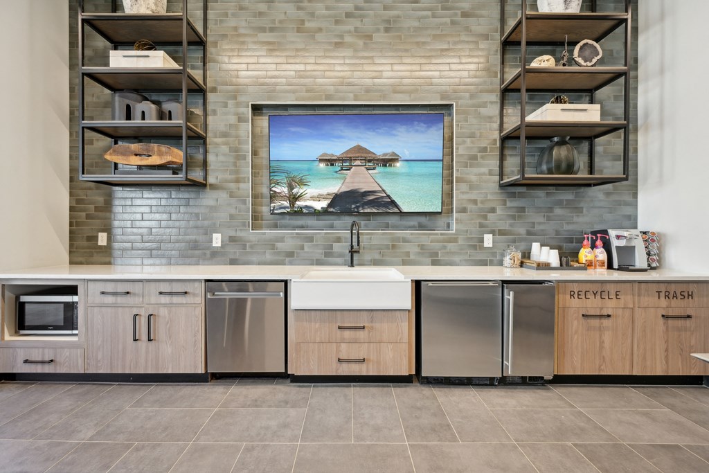 A kitchen with a large painting of a beach scene on the wall.