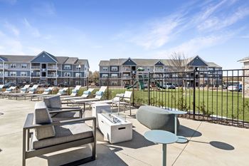 A sunny day at a resort with lounge chairs and tables.