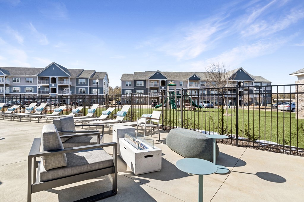 A sunny day at a resort with lounge chairs and tables.