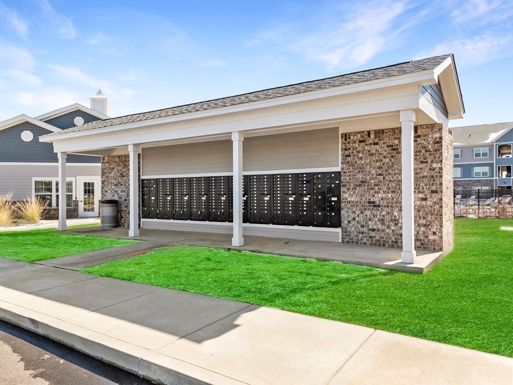 A small building with a stone wall and a black board on the wall.