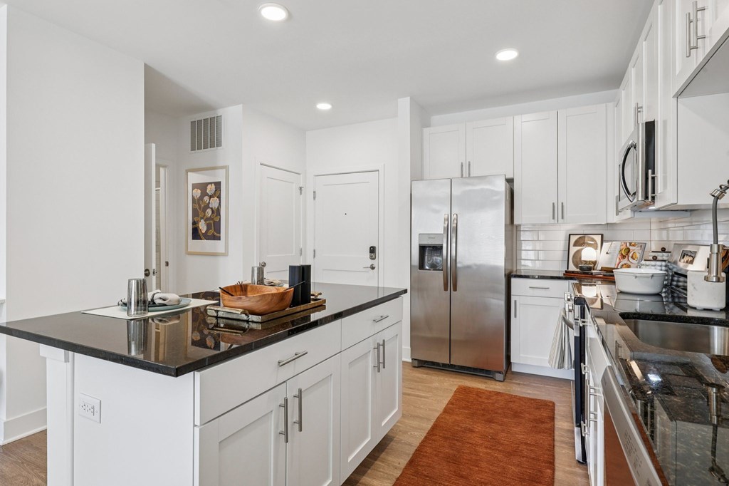 Open-concept kitchen and living area at Contrast OTR in Over-the-Rhine, Cincinnati with hardwood flooring and designer finishes.
