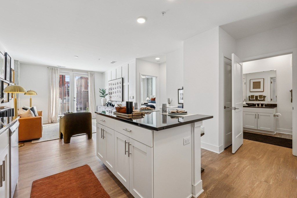 A modern kitchen with white cabinets and a black countertop.